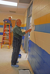 Silver Dollar City founder Peter Herschend paints a wall at Crane High School.